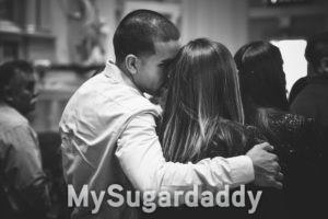 Mann hält Frau im Arm Flirten beim Ernsten Typ